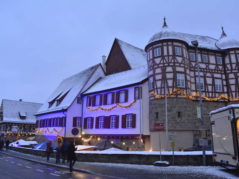 Leuchtende Sternlampen mit durchbrochenen Mustern hängen in einer dunklen Umgebung, wodurch ein stimmungsvolles, farbenfrohes Lichtspiel entsteht.