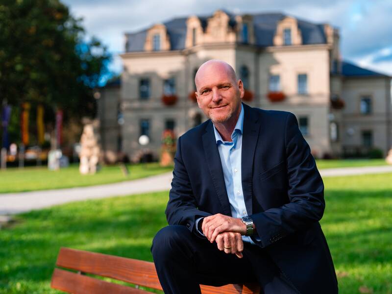 BM Stephen Brauer vor dem Neuen Schloss (Rathaus) im Hintergrund